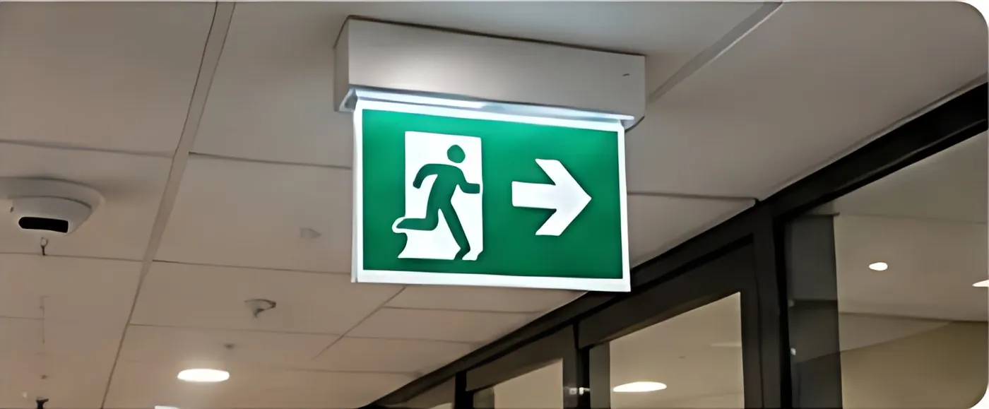 Illuminated emergency exit sign in a corridor