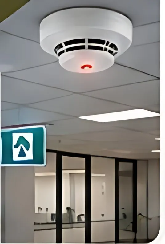 Smoke detector and exit sign on a ceiling